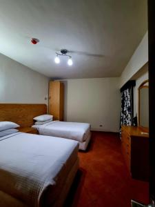 Cette chambre comprend deux lits et un bureau. dans l'établissement Porto sokhna Pyramids Apartments, à Ain Sokhna