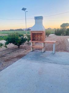 een bank op een stoep naast een veld bij Mas de Melonet Delta del Ebro in L'Aldea