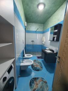 ドゥラスにあるNorris Apartmentの青と白のバスルーム(洗面台2台、トイレ付) +18枚の写真