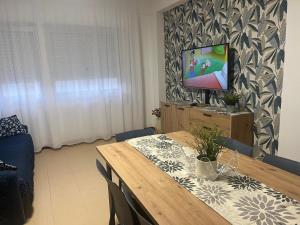 a dining room with a table and a tv on a wall at Profumo di Mare 2 in Alcamo Marina