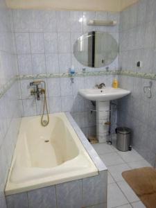 a white bathroom with a tub and a sink at BERGET ZACA in Ouagadougou +4 photos