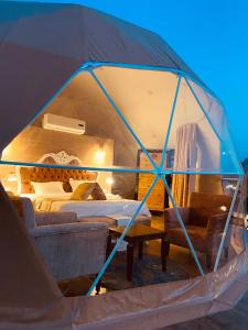 namiot z łóżkiem i stołem w obiekcie Faisal Wadi Rum camp w mieście Wadi Rum
