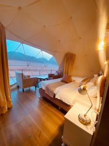 Faisal Wadi Rum camp في وادي رم: غرفة نوم في خيمة مع سرير وكرسي