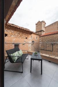 una silla y una mesa en un balcón con un edificio en CASA RURAL MENSIN en Vilar de Canes