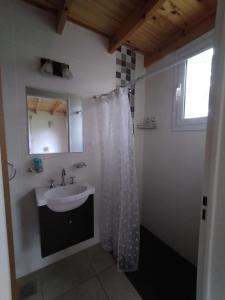 a bathroom with a sink and a shower curtain at Maika in Sierra de la Ventana
