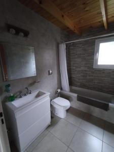 a bathroom with a white toilet and a sink at Maika in Sierra de la Ventana +13 photos