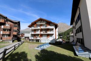 ein Apartmenthaus mit einer Liegewiese davor in der Unterkunft Nicoletta in Saas-Fee