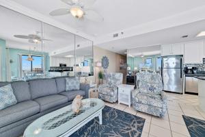a living room with a couch and chairs and a kitchen at Phoenix 5 Unit 1417 in Orange Beach