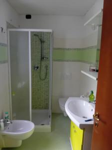 une salle de bain blanche avec deux lavabos et une douche dans l'établissement La casa di Bobo, à Pian degli Ontani