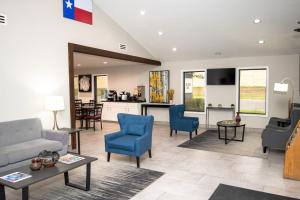 a living room with a couch and chairs and a kitchen at Americas Best Value Inn Harlingen in Harlingen