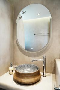 La salle de bains est pourvue d'un lavabo en bois et d'un miroir. dans l'établissement Filokalia 4 Veins - Vacation House with Sea View, à Karistos
