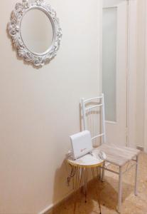 a mirror and a chair with a laptop on a table at A-Apartments -- Agiou Therapontos in Athens