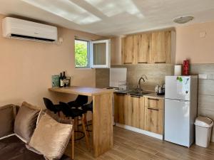 a kitchen with a table and a white refrigerator at Lakeside Harmony Apartment in Golubovci