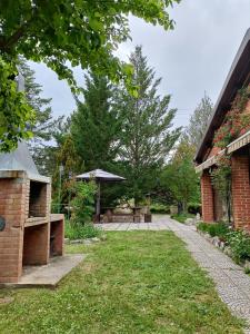 a garden with a brick building and an umbrella at Finca Paraíso Rural in El Burgo de Osma