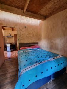 a large bed in a room with wooden walls at cabaña trafwe in Lago Ranco