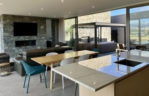 a living room with a table and a fireplace at Luxury Lakeview Apartment - Lake Tekapo in Lake Tekapo