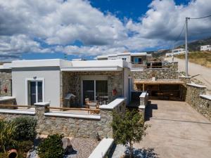 una casa con un muro in pietra e un patio di Filokalia 4 Veins - Vacation House with Sea View a Karistos