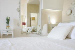 1 dormitorio con cama blanca y espejo en Sea Suites, en Ugento