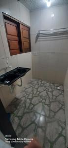 ein Bad mit einem Waschbecken und Fliesenboden in der Unterkunft Recanto do Mar em Peroba 02 in Maragogi