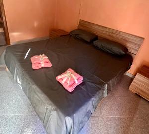 a bed with two pink towels on top of it at La casa storica in Santu Lussurgiu +25 photos