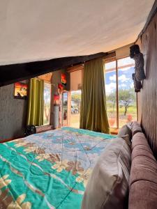 Cette chambre comprend un grand lit et une fenêtre. dans l'établissement Kilimanjaro view cabin-Amboseli, à Oloitokitok 