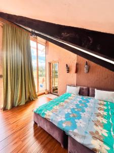 Kilimanjaro view cabin-Amboseli في Oloitokitok : غرفة نوم بسرير ونافذة كبيرة