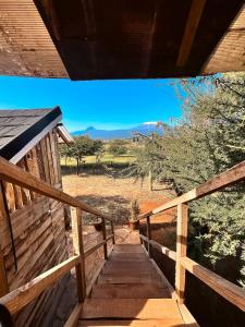 eine Holztreppe, die zu einer Veranda eines Hauses führt in der Unterkunft Kilimanjaro view cabin-Amboseli in Oloitokitok 