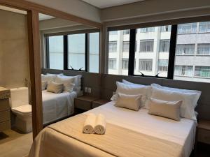 - 2 lits dans une chambre avec 2 fenêtres dans l'établissement Life Residence, à Belo Horizonte