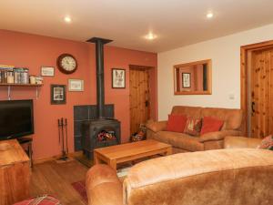 sala de estar con sofá y chimenea en The Barn en Sedbergh