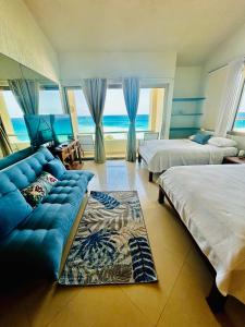 sala de estar con 2 camas y sofá azul en Solymar corner penthouse condo en Cancún