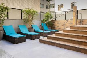 un gruppo di sedie blu su un patio con scale di Life Residence a Belo Horizonte