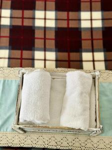 two white towels in a basket on a table at Errika's Sweet Home in Provatas