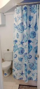 a bathroom with a blue and white shower curtain at Chez Emmanuel in Gros Islet