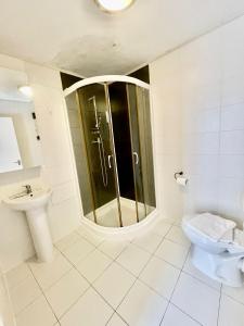 uma casa de banho com um chuveiro e um WC. em Cromwell Apartments em Londres