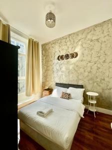 um quarto com uma cama branca e uma janela em Cromwell Apartments em Londres