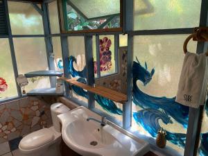La salle de bains est pourvue d'un lavabo et d'un dragon peint sur le mur. dans l'établissement Franky's Fare, à Fare