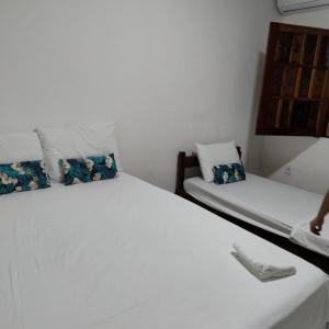 a bedroom with two beds with blue flowers on them at Pousada Vila Jesuita in Cairu