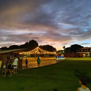 a group of people walking around a park at night at Pousada Vila Jesuita in Cairu