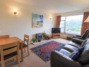 a living room with a couch and a table and a television at Fellcroft in Ambleside