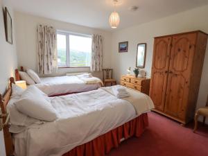 a bedroom with two beds and a window at Fellcroft in Ambleside