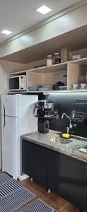 uma cozinha com um frigorífico branco e um micro-ondas em Eco Flat Recife - Vista ao Mar de Boa Viagem no Recife