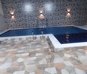 a swimming pool with two faucets on a stone wall at Recanto do Mar em Peroba 02 in Maragogi