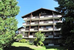 an apartment building with trees in front of it at Everest in Saas-Fee