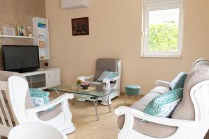 a living room with chairs and a tv and a table at Villa Pontem in Komarna