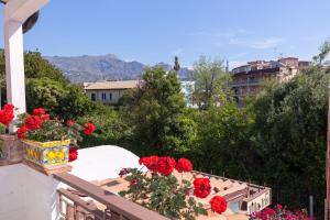 balkon z czerwonymi kwiatami na budynku w obiekcie Villa Iris w mieście Giardini Naxos
