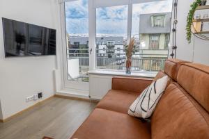 Una sala de estar con un sofá y una ventana grande. en LL Properties - H81 Charming Deluxe Apartment, en Akureyri