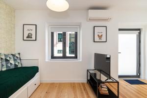 a bedroom with a bed and a flat screen tv at Design and bright studios near Pastéis de Belém in Lisbon