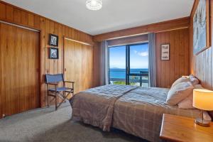 - une chambre avec un lit et une vue sur l'océan dans l'établissement Mayor Magic - Onemana Holiday Home, à Opoutere