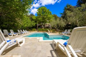 a swimming pool with lounge chairs and a swimming poolvisorvisor at Villa Elizabeta in Pula