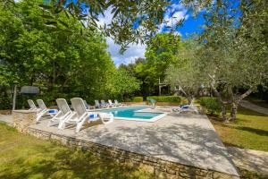 a group of lounge chairs and a swimming pool at Villa Elizabeta in Pula